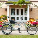 Een orthopedische driewieler bij een rustig verpleeghuis, omgeven door een levendige tuin.